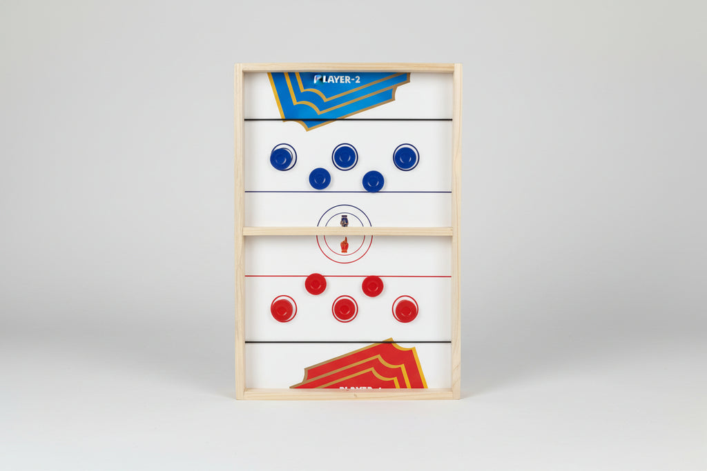 Wooden air hockey table with red and blue pucks on a dark background